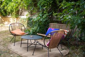 two chairs and a table next to a bench at 1 Peraudel Suite & Appartements in Castres