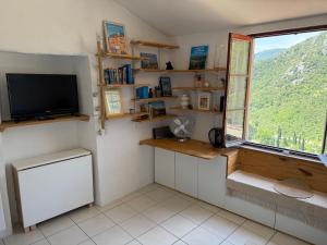 a room with a television and a window with a view at Studio with sea and mountain view in Sainte-Agnès
