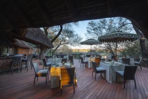 a restaurant with tables and chairs on a wooden deck at Last Word Makanyane in Laastepoort