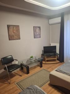 a living room with a bed and a table and a chair at Velvet Motel in Hegyeshalom