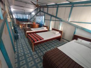 a room with three beds and a table and chairs at Terrace Camp inn in Tiruchirappalli