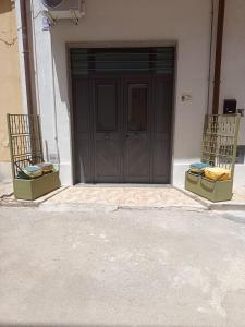 two chairs sitting in front of a brown door at Curtigghiu Room in Avola