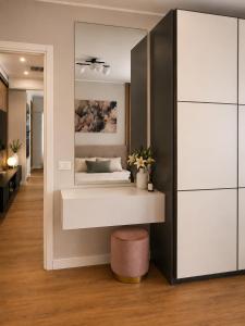 a living room with a mirror and a stool at The Captain's Apartments Marina - next to Verbella - Leonardo Academy, MXP in Sesto Calende