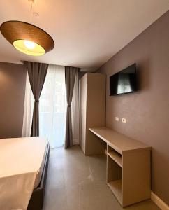 a room with a bed and a desk and a television at Galliera Residence B&B in Bologna