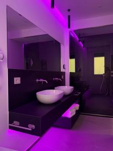 a bathroom with two sinks and purple lights at Galliera Residence B&B in Bologna +64 photos