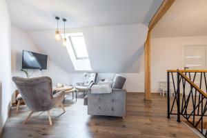 a living room with a couch and chairs and a tv at Cozy mountain house - Coolówka pod Babią Górą in Zubrzyca Dolna