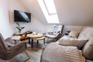 a living room with a couch and chairs and a tv at Cozy mountain house - Coolówka pod Babią Górą in Zubrzyca Dolna