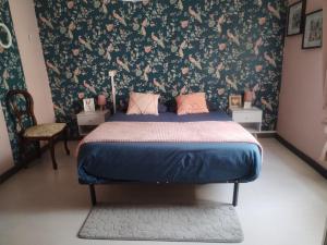 a bedroom with a bed with a floral wallpaper at Le Nichoir de Lesmont in Lesmont