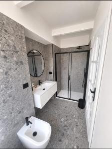 a bathroom with a sink and a toilet and a mirror at Mulimù - Guesthouse in Montecalvo Versiggia