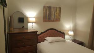 a bedroom with a bed with a dresser and a mirror at Maindee Guest House in Barrow in Furness