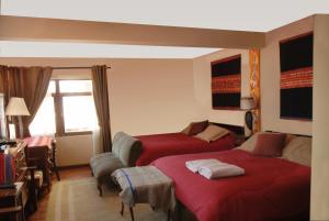 Habitación de hotel con 2 camas y ventana en Rendezvous Hostal, en La Paz