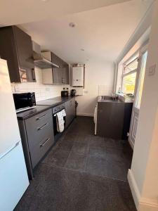 a small kitchen with gray cabinets and a sink at Alexandra View in Goole