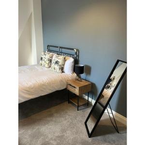 a bedroom with a bed and a table with a mirror at Alexandra View in Goole