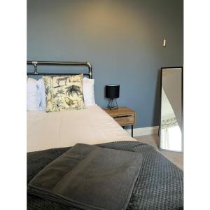 a bedroom with a white bed with a mirror at Alexandra View in Goole +2 photos