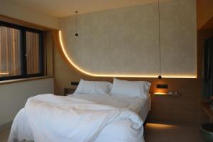a bedroom with a bed with white sheets and pillows at Acouga in Miñortos
