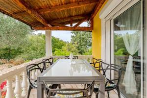 a table and chairs on the porch of a house at Villa Sunshine in Pridraga