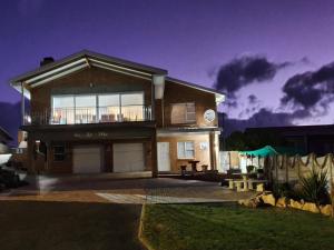 a large house with a balcony in front of it at The Goose Nest in Struisbaai