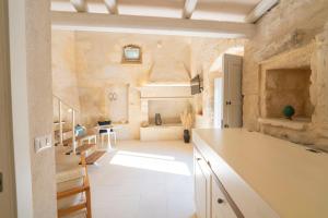 a large kitchen with a stone wall at HISTORIA - Dimore in Corte in Borgagne +22 photos