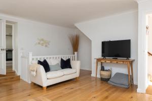 a living room with a white couch and a flat screen tv at NEW - Herricks by The Butler Collection in Arundel