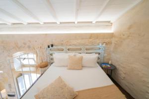 a bedroom with a white bed in a room at HISTORIA - Dimore in Corte in Borgagne