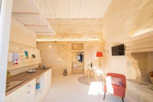 a kitchen with a table and a chair in a room at HISTORIA - Dimore in Corte in Borgagne