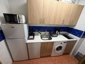 a small kitchen with a sink and a microwave at La Sima del Anillo in Cardaño de Abajo