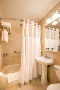 a bathroom with a white shower curtain and a sink at Hotel Beacon in New York