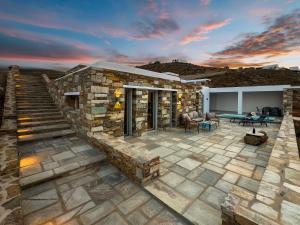 a stone house with a stone staircase and a patio at Villa Plora, by Estia in Áno Meriá