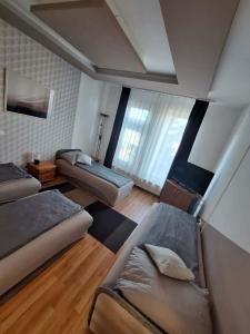 a room with two beds and a couch in it at Velvet Motel in Hegyeshalom