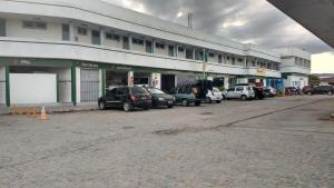 une rangée de voitures garées devant un bâtiment dans l'établissement Pousada Araguaia, à Agrestina