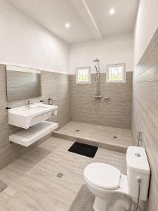 a white bathroom with a sink and a toilet at Hôtel Sofia Bellevue in Antsohihy +37 photos
