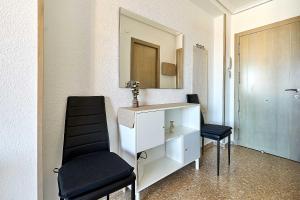 a bathroom with a sink and two black chairs at Espanhouse Vera Torreblanca in Torrevieja +49 photos