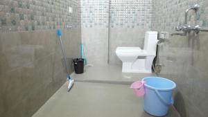 a bathroom with a toilet and a trash can at Dimora Homes, Bir in Bīr