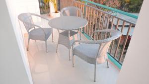 three chairs and a table on a balcony at Dimora Homes, Bir in Bīr