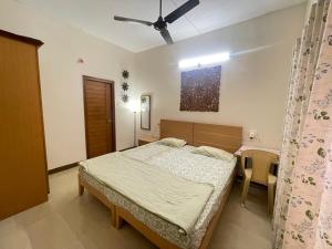 a bedroom with a bed and a ceiling fan at Neha's Homestay in Mysore