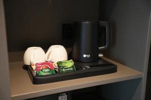 a black coffee pot sitting on a shelf at Keruen inn Karaganda in Karagandy