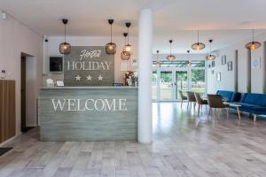 a hotel lobby with a welcome sign on the counter at Holiday Hotel Siófok in Siófok