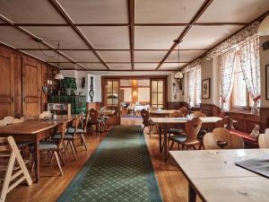 a restaurant with wooden tables and chairs and a green rug at Hochfirst Waldlodge in Lenzkirch