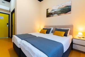 a bedroom with a large bed with two yellow pillows at Green Cube Capsule Hostel in Sofia