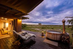 a deck with a hot tub and chairs on a house at Onguma The Fort in Namutoni Gate