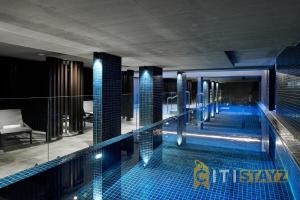 a swimming pool with blue tiles in a building at Braddon Base in The Midnight, Heated Pool & Sauna in Braddon