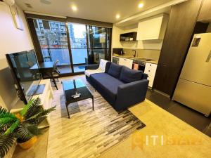 a living room with a couch and a table at Braddon Base in The Midnight, Heated Pool & Sauna in Braddon