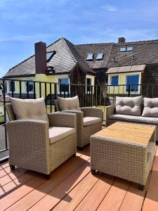 a group of wicker chairs and tables on a deck at Art Residence Goldener Löwe in Bodman-Ludwigshafen