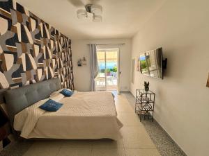 a bedroom with a bed with blue pillows on it at To Be Capri Sea view Rooms in Capri