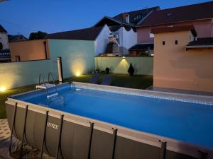 a swimming pool in the backyard of a house at night at Apartman Cherry in Višnjevac