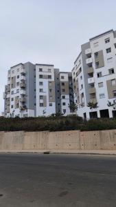 two large white apartment buildings on the side of a street at Sunset Stay Anza in Agadir