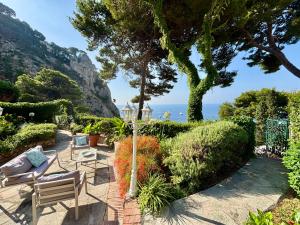 a garden with a table and chairs and a view of the ocean at To Be Capri Sea view Rooms in Capri