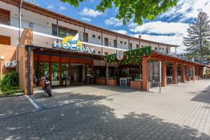 a building with a motorcycle parked in front of it at Holiday Hotel Siófok in Siófok
