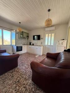 a living room with two couches and a kitchen at Antilia corfu 4 in Agios Georgios