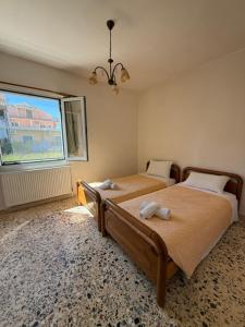 a bedroom with two beds and a window at Antilia corfu 4 in Agios Georgios